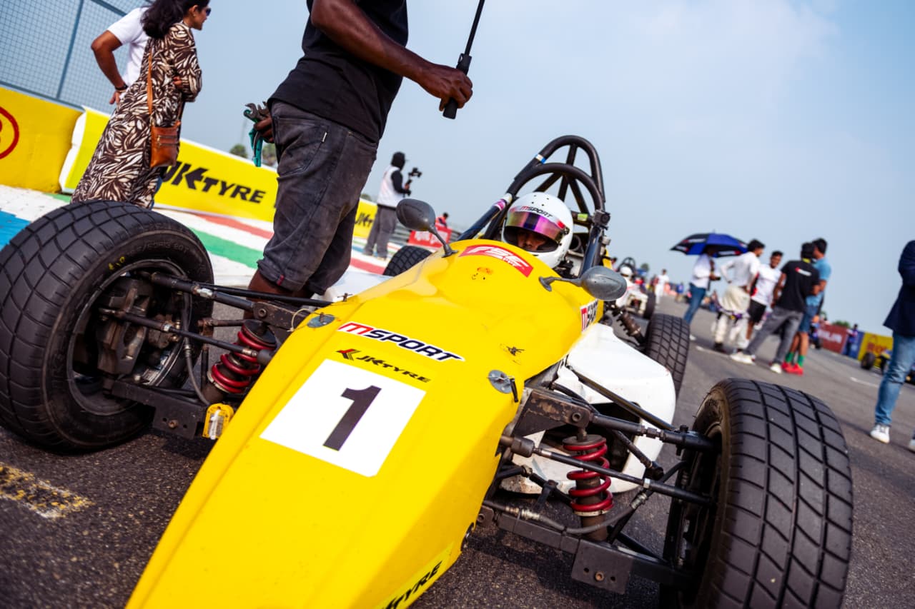 Avi Malavalli beside a yellow formula racing car